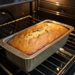 A perfectly risen banana bread baking in the oven.
